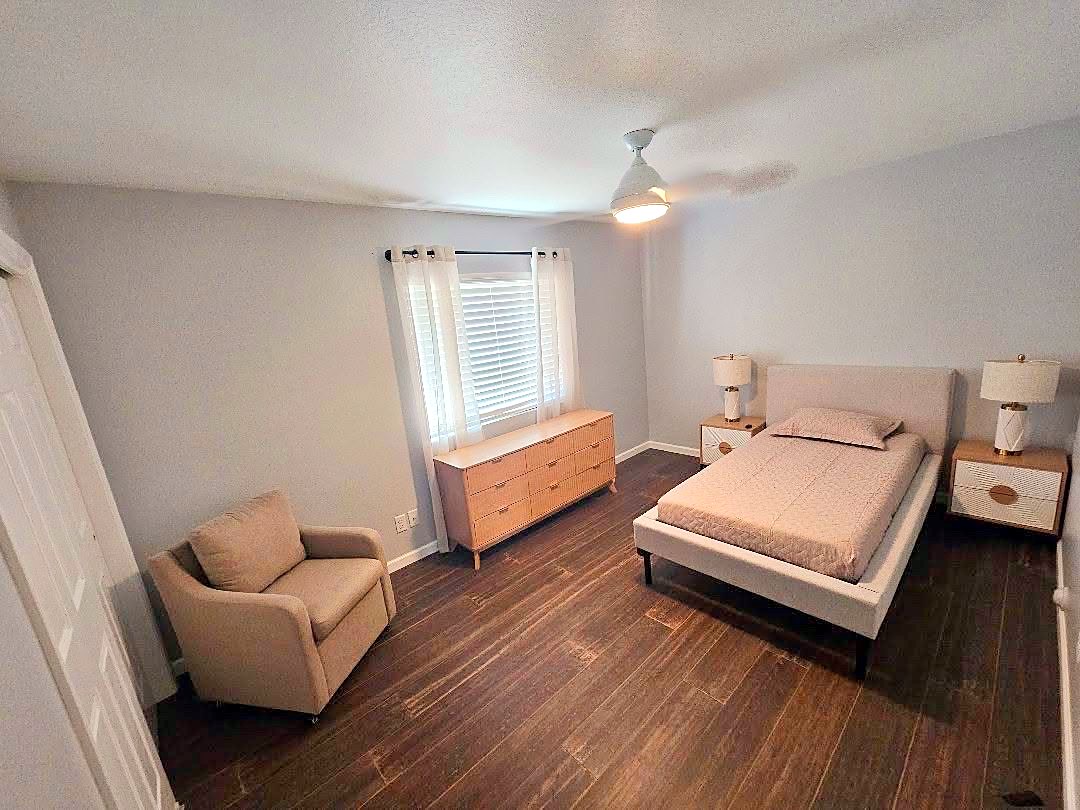 Second private bedroom with a bed, armchair, dresser, and window